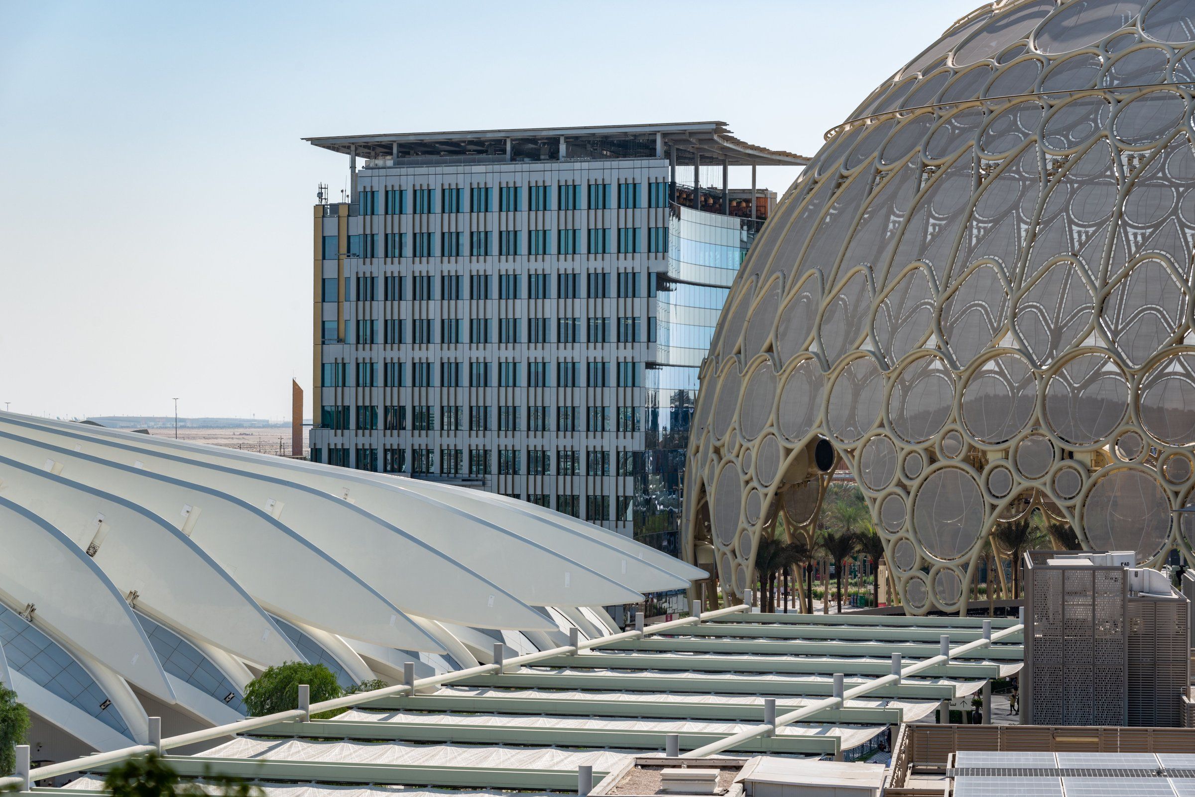 Купол Al Wasl в Expo City днём: ажурная золотистая оболочка, за ним стеклянное здание, слева белая кровля павильона